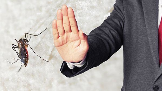 a man swatting a bug in an office