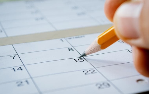 a hand marking a calendar